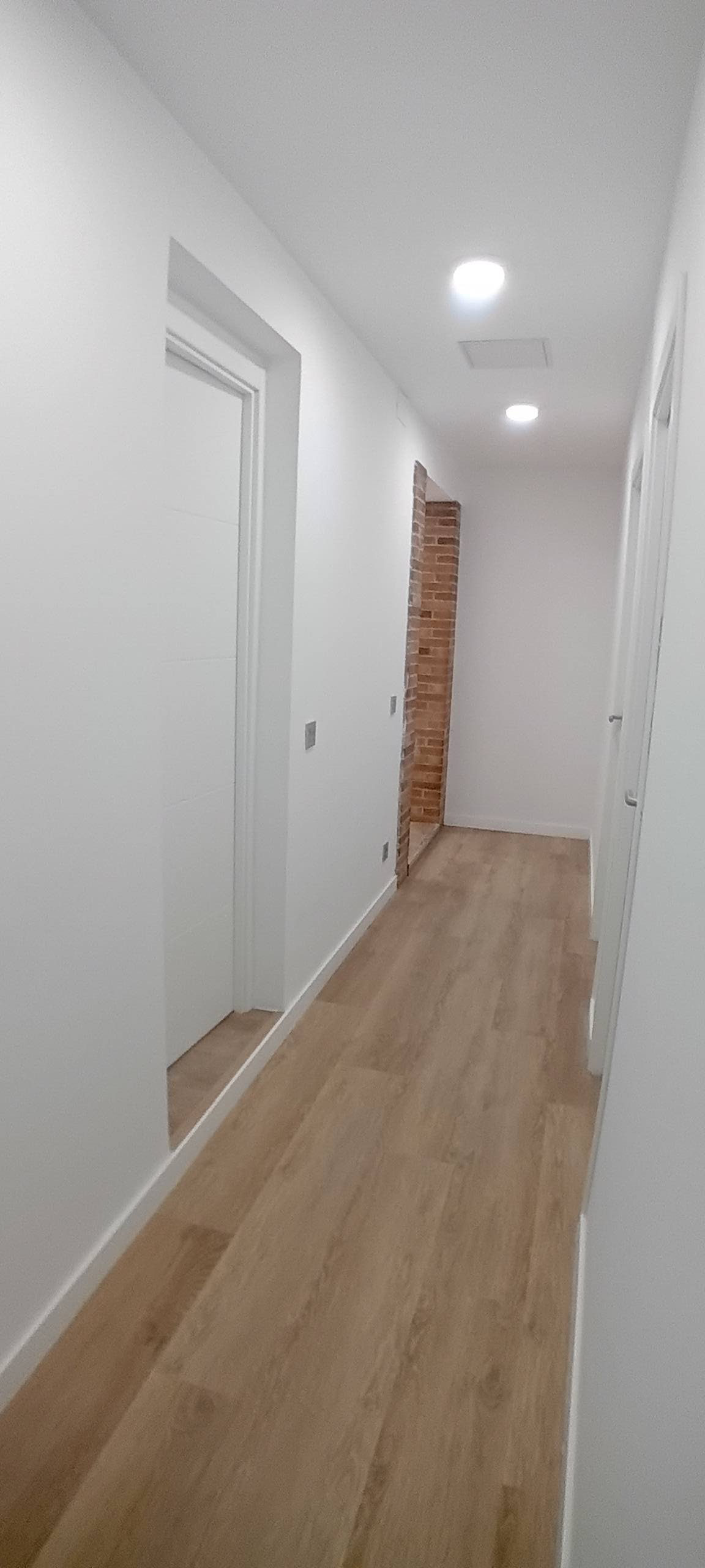 pasillo blanco con suelo de madera
